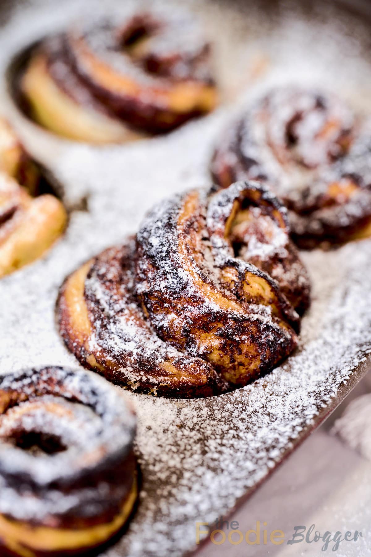 nutella cruffins in a muffins tin with sugar sprinkled on top