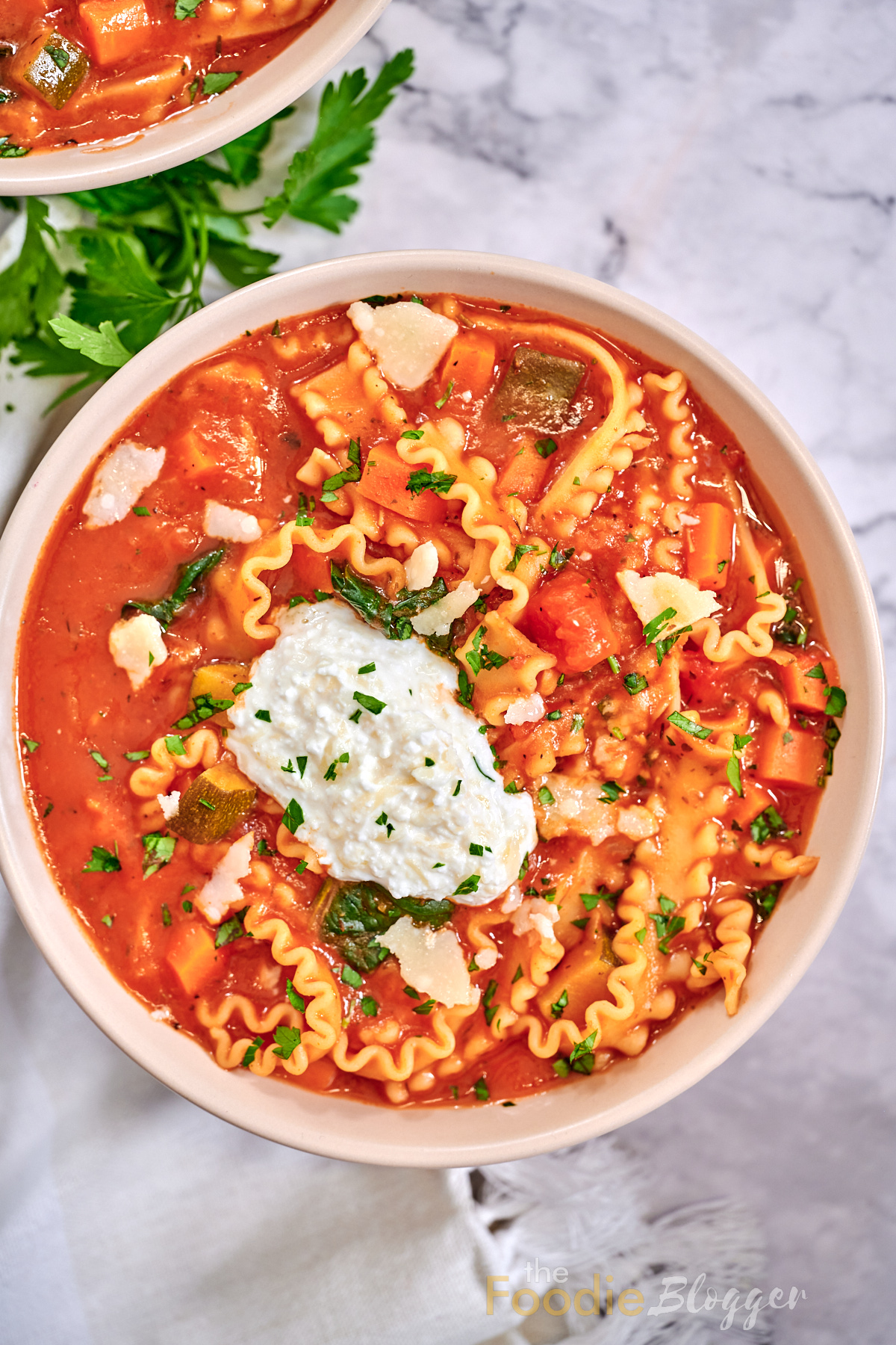 vegetarian lasagna soup in a bowl topped with ricotta cheese blend