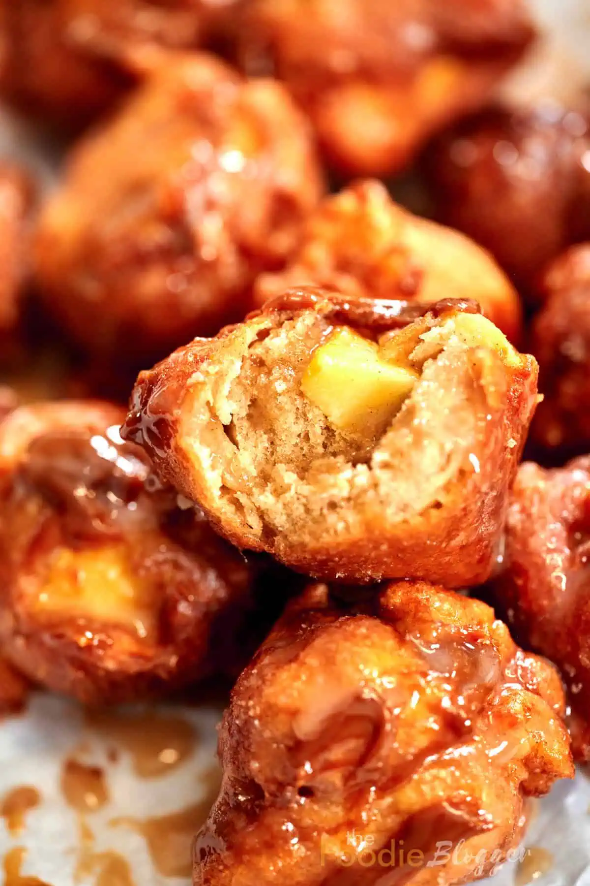 Texture of a fluffy apple fritter, revealing chunks of apple inside