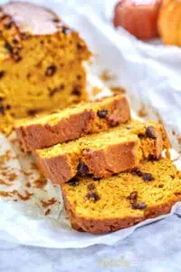 A loaf of Easy Pumpkin Chocolate Chip Bread, freshly baked with a golden brown crust and chocolate chips throughout.