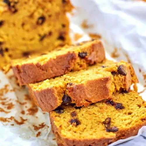 A loaf of Easy Pumpkin Chocolate Chip Bread, freshly baked with a golden brown crust and chocolate chips throughout.