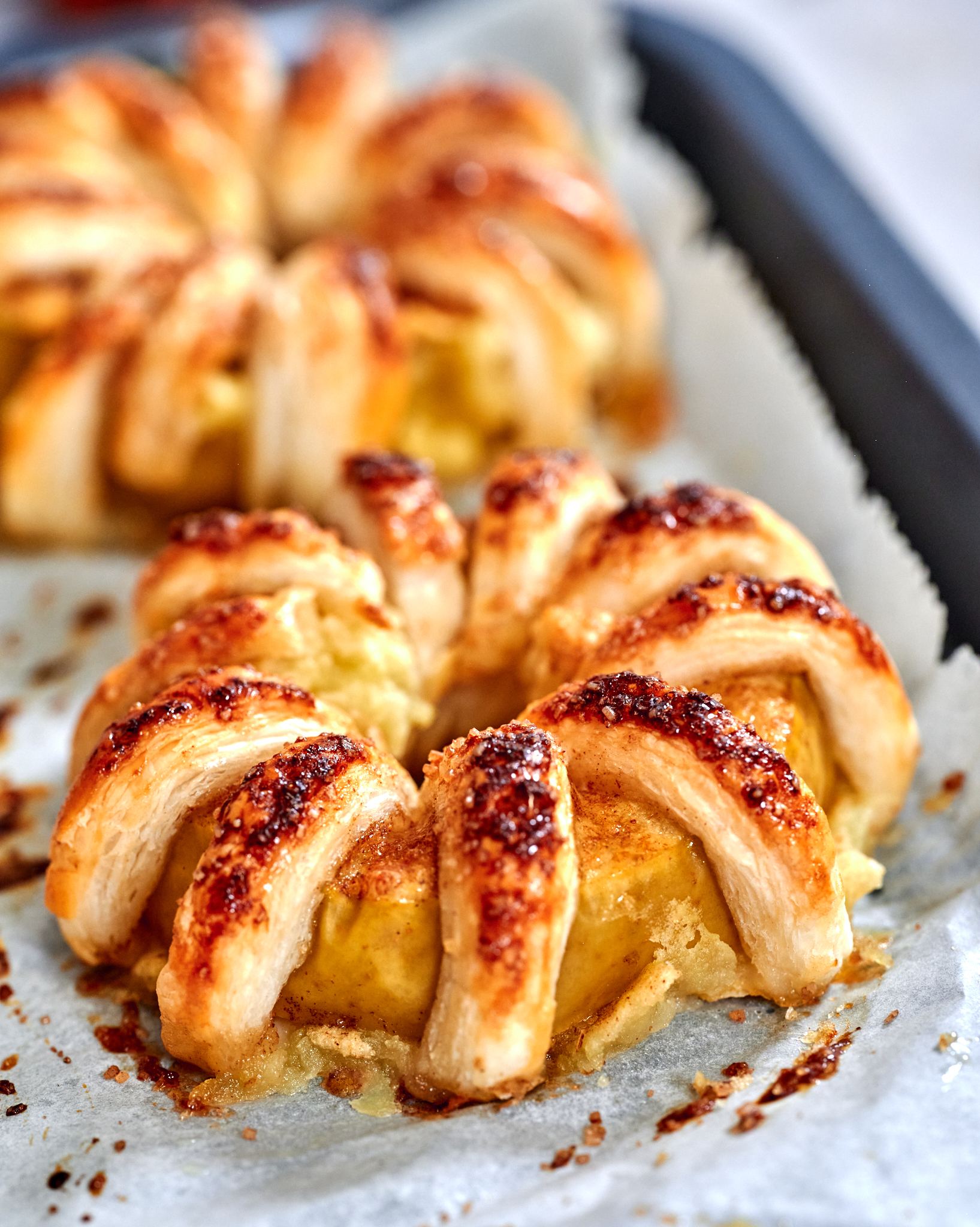 Puff Pastry Apple Rings 5 An apple pastry wreath finished with amber caramel, the sauce pooling between the baked doughโs layers and highlighting the soft apples inside.