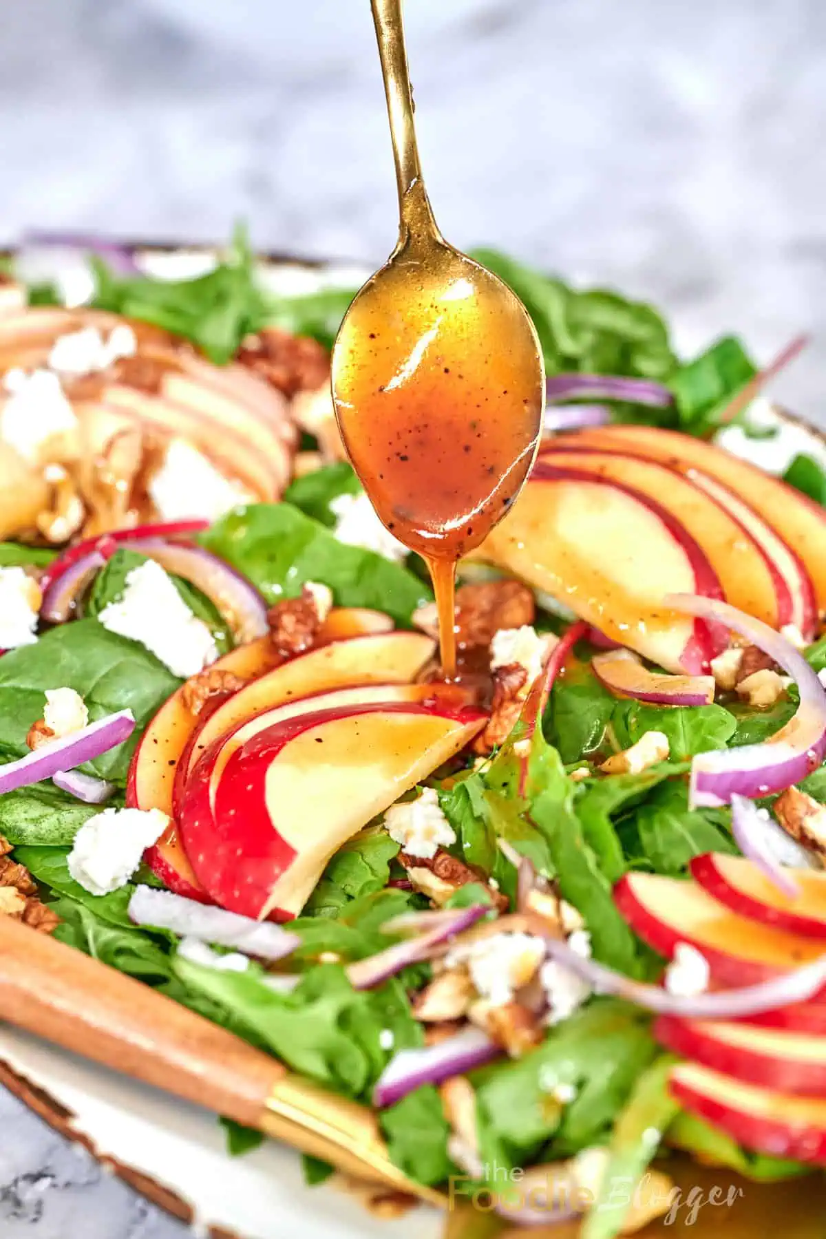 Apple Walnut Salad 8 Spoonful of honey-balsamic dressing drizzling over apple, walnut, and feta spinach salad.