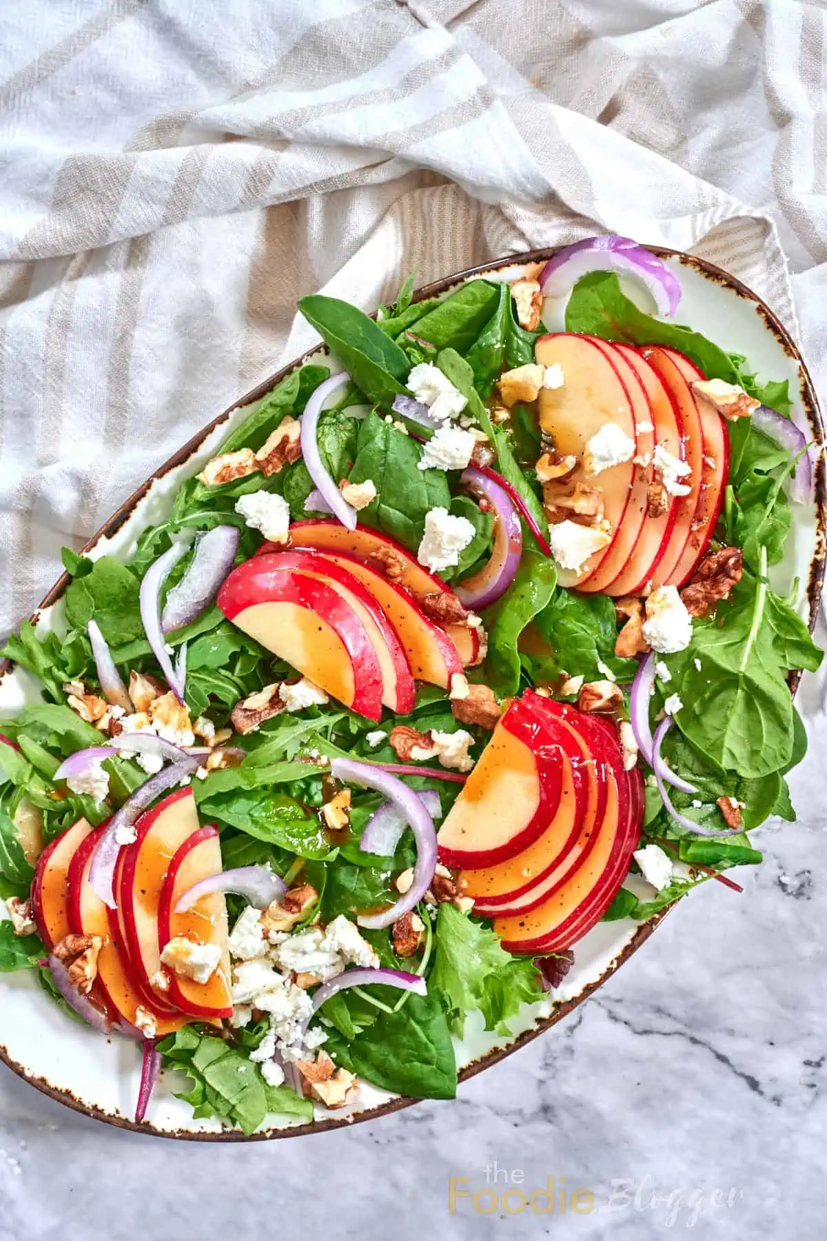 Apple Walnut Salad 9 Fresh apple-walnut salad presentation on marble with striped linen underneath.