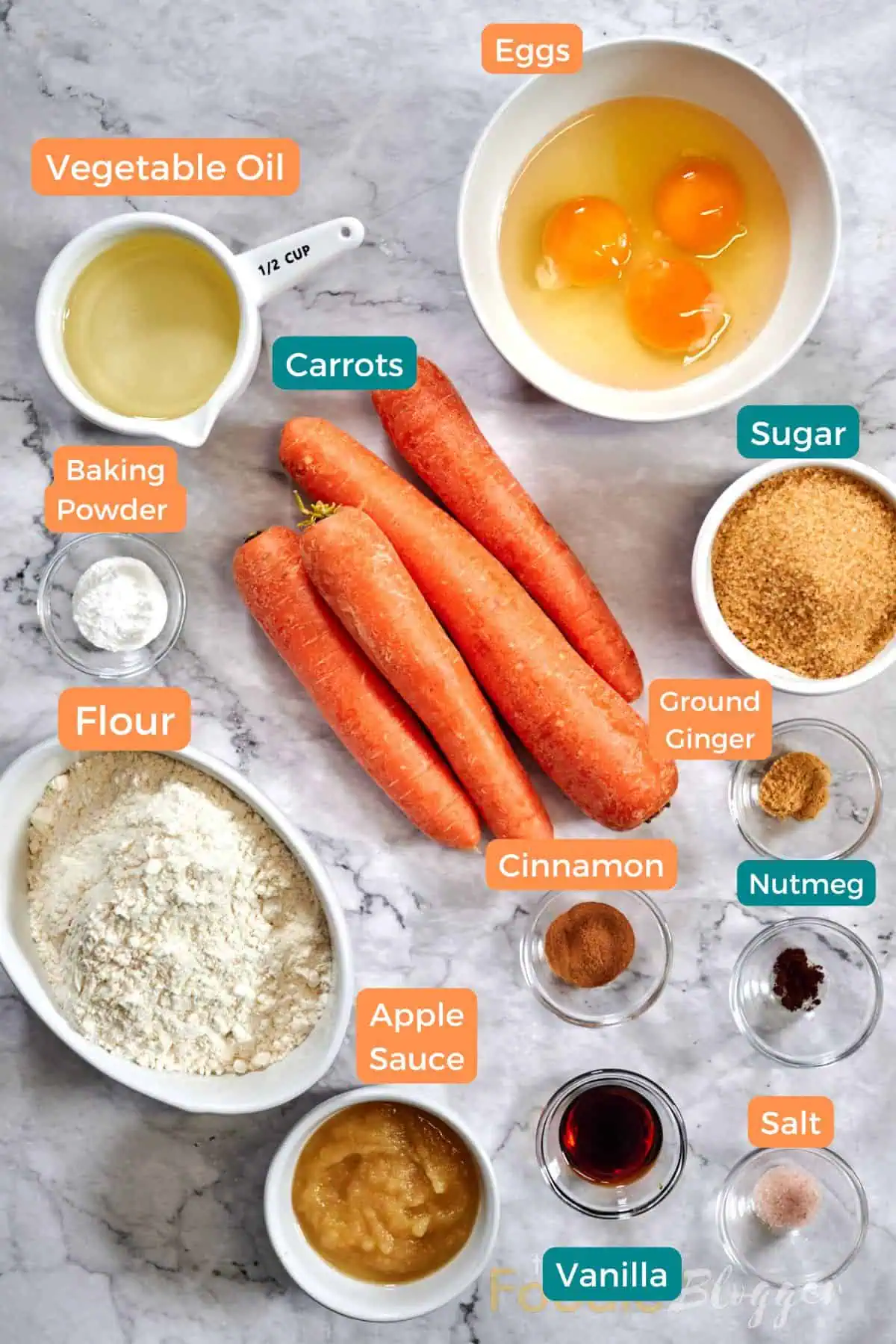 Carrot Cake Bars 3 Ingredient spread for spiced carrot cake bars: a bunch of carrots, three cracked eggs, flour in an oval dish, applesauce, cup of oil, sugar, baking powder, vanilla extract, salt, cinnamon, ground ginger, and nutmeg, all tagged.