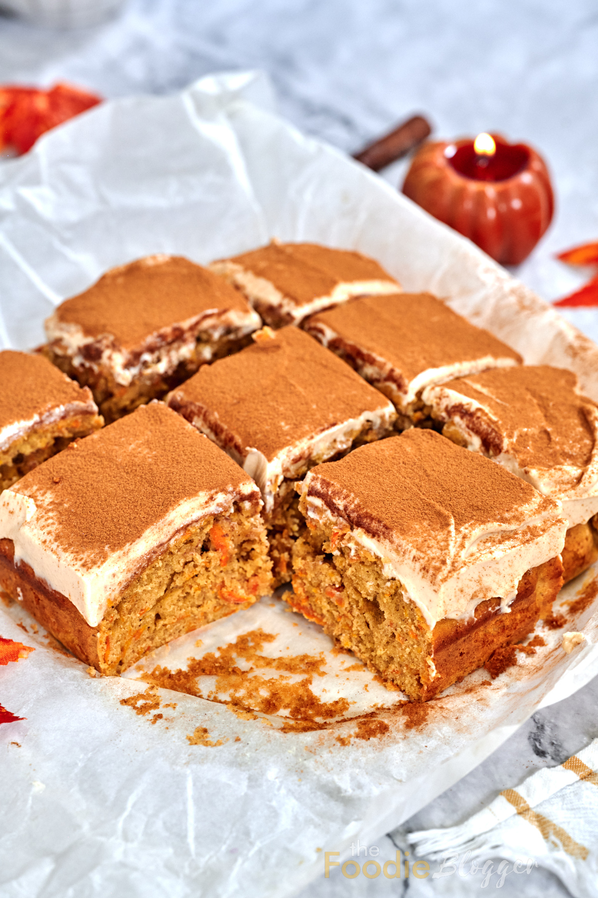 Carrot Cake Bars 2 A full pan of carrot cake bars cut into neat squares, their creamy frosting swirls and cinnamon crowns glistening under soft light.
