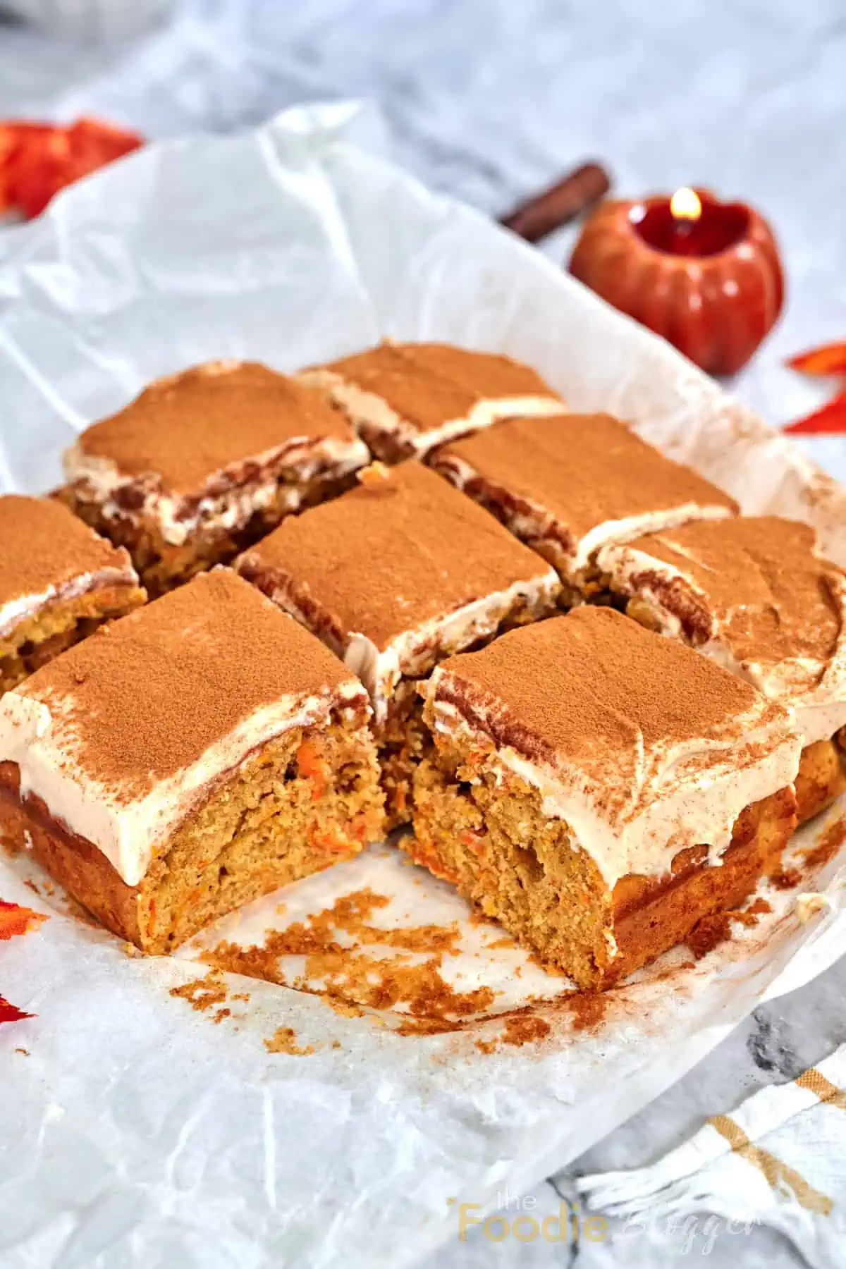 Carrot Cake Bars 2 A full pan of carrot cake bars cut into neat squares, their creamy frosting swirls and cinnamon crowns glistening under soft light.