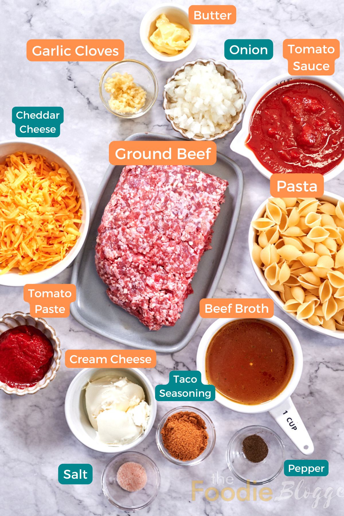 Cheesy Taco Pasta (One Pot) 3 Ingredients for one-pot cheesy taco pasta: ground beef, shell pasta, tomato sauce and paste, shredded cheddar, cream cheese, beef broth, diced onion, minced garlic, butter, taco seasoning, salt and pepper.