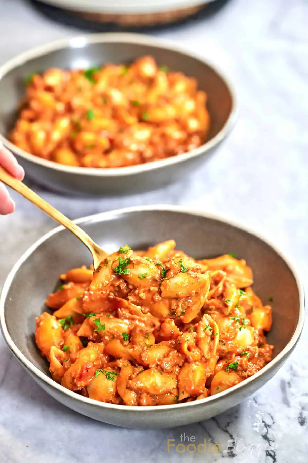 Cheesy Taco Pasta (One Pot) 2 Bowl of shell pasta coated in creamy tomato-cheddar taco sauce with crumbled beef and a sprinkle of parsley.