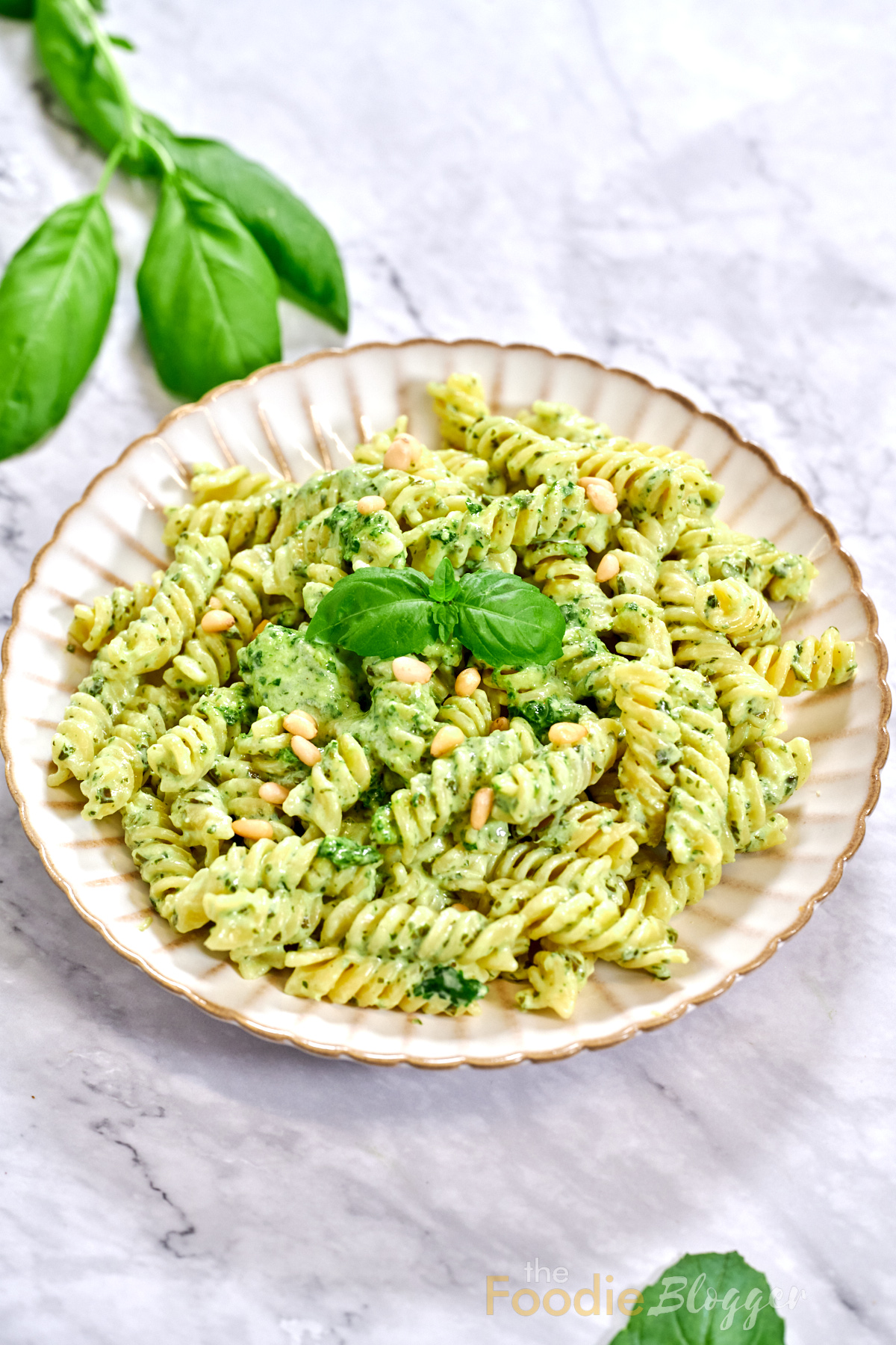 Creamy Pesto Pasta 1 Lunch-ready pesto pasta, pine nuts glistening like little pearls, basil leaves just out of focus in the corner.