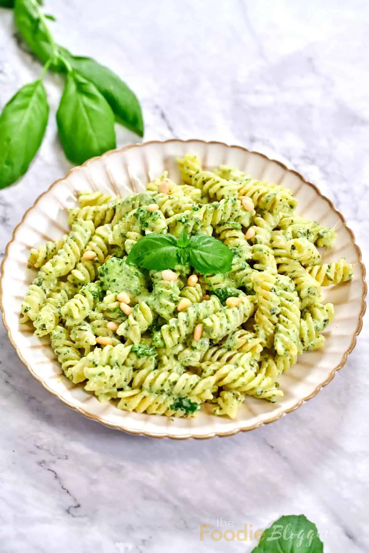 Creamy Pesto Pasta 1 Lunch-ready pesto pasta, pine nuts glistening like little pearls, basil leaves just out of focus in the corner.