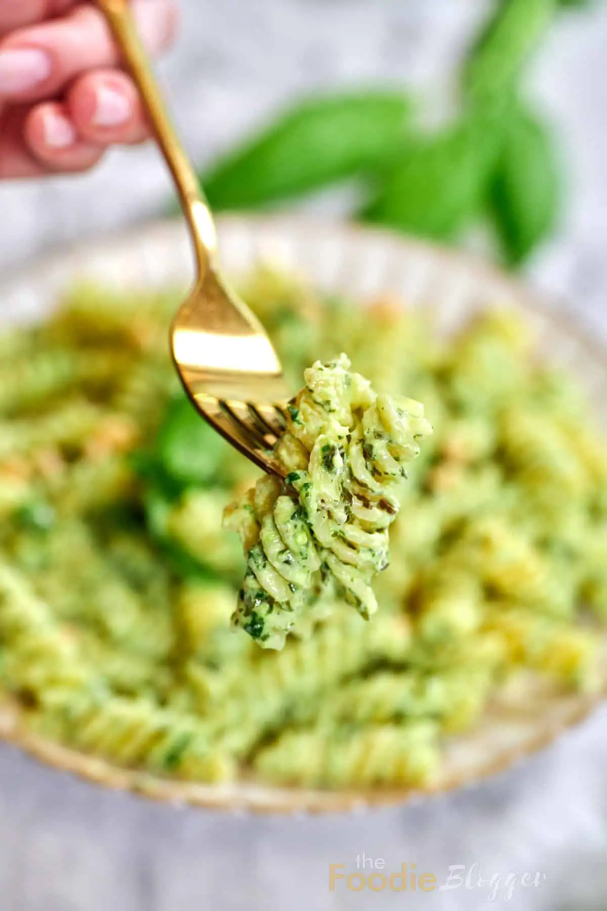 Creamy Pesto Pasta 2 Close-up bite shot: glossy green noodles cling together, dotted with tiny basil bits.