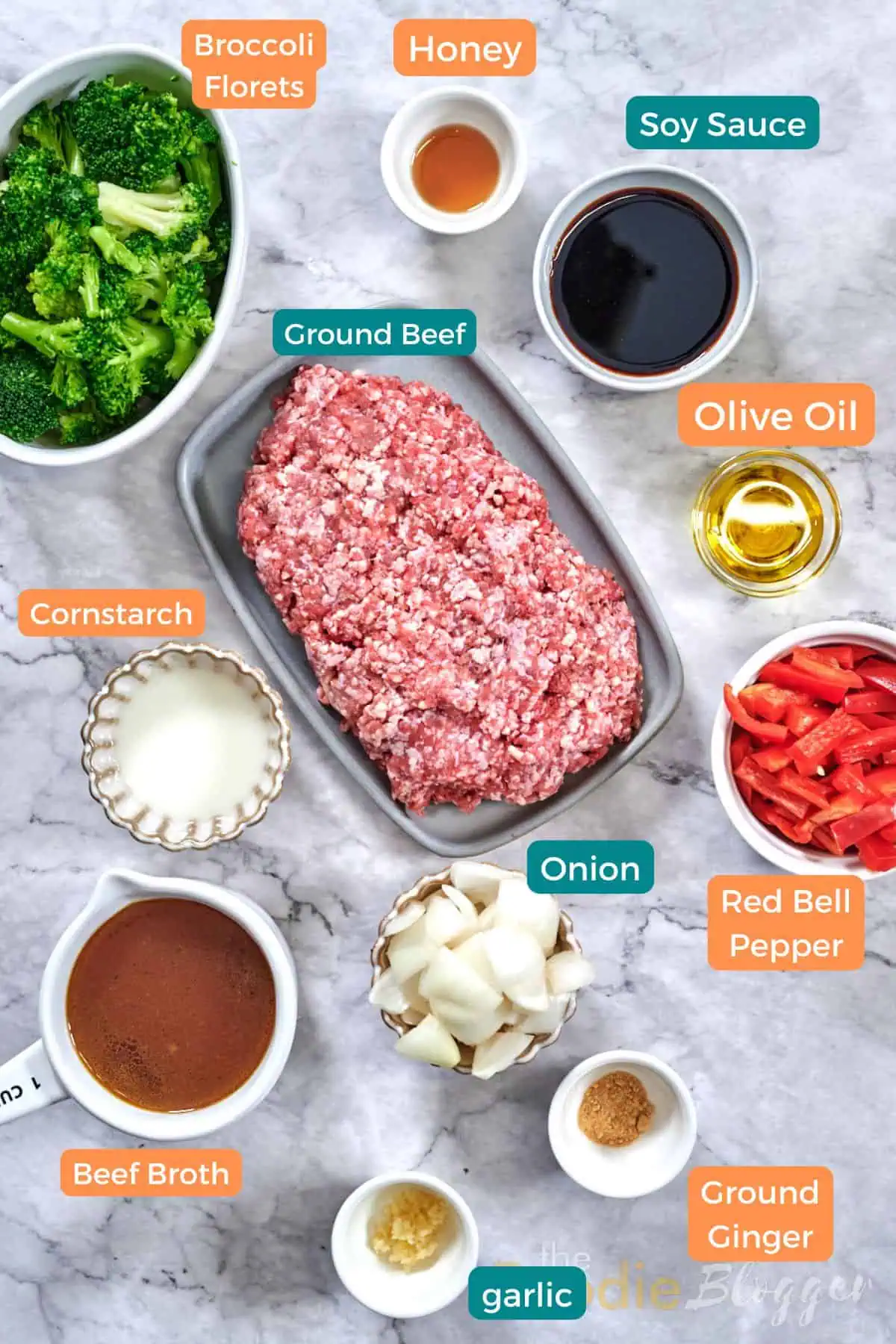 Ground Beef And Broccoli Stir Fry 3 Flat-lay of stir-fry ingredients: ground beef, blanched broccoli, red bell pepper, onion chunks, soy sauce, beef broth, honey, olive oil, cornstarch, garlic, and ground ginger.