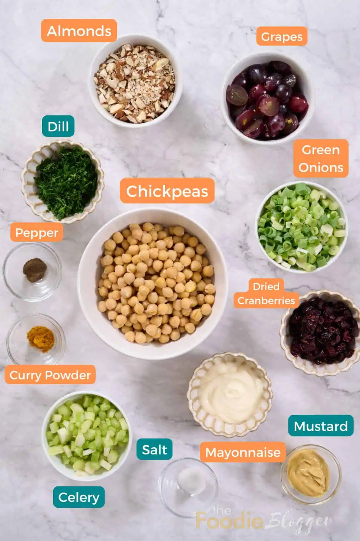 Vegan Chicken Salad 3 Flat-lay of labeled ingredients for vegan chicken salad: chickpeas, grapes, almonds, celery, green onions, and more on marble.