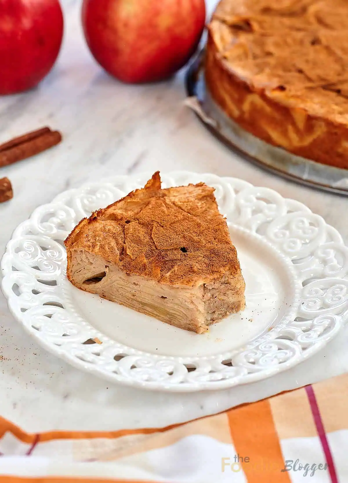 Invisible Apple Cake 13 Slice of invisible apple cake served on a decorative white plate with cinnamon.