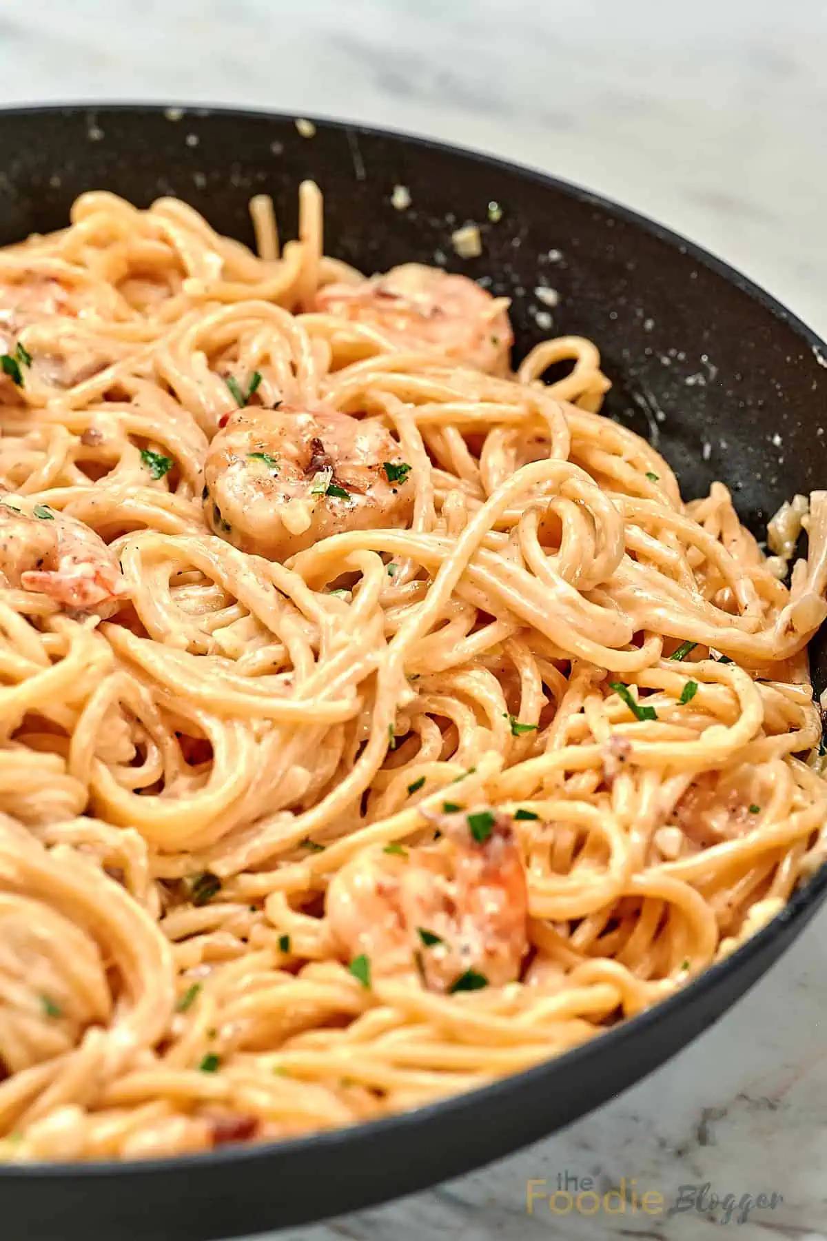 The Foodie Blogger - Tried, True, and Delicious Recipes 3 Close-up of ultra creamy garlic parmesan shrimp pasta in a skillet with tender shrimp and spaghetti tossed in a smooth garlic parmesan cream sauce