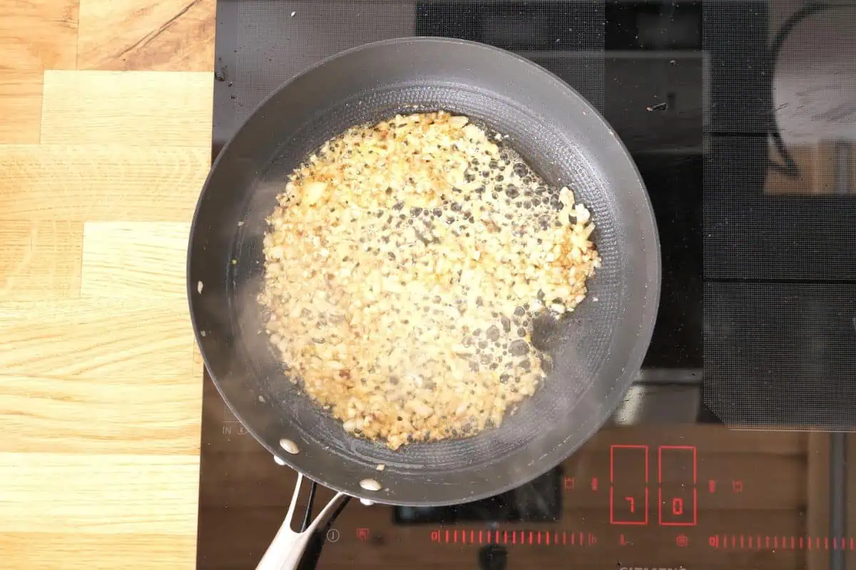 Ultra Creamy Garlic Parmesan Shrimp Pasta 7 Softened onion and garlic cooking in a skillet until lightly golden for creamy shrimp pasta sauce