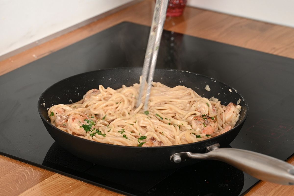 Ultra Creamy Garlic Parmesan Shrimp Pasta 12 Ultra creamy garlic parmesan shrimp pasta being tossed in a skillet until evenly coated