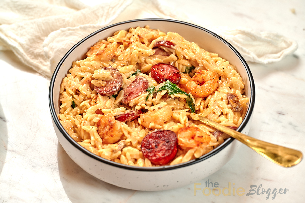 Creamy Cajun Shrimp Orzo 15 Bowl of creamy Cajun shrimp orzo with smoked sausage, spinach, and a creamy parmesan sauce.