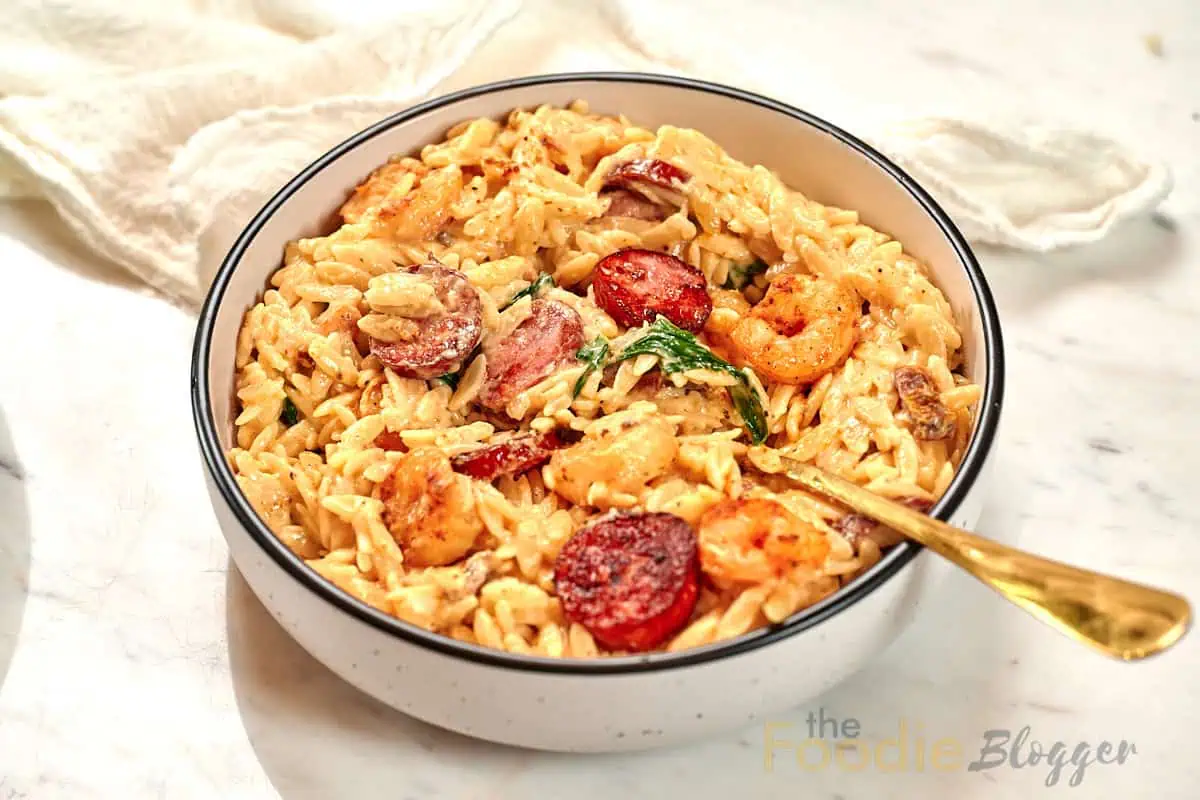 Creamy Cajun Shrimp Orzo 15 Bowl of creamy Cajun shrimp orzo with smoked sausage, spinach, and a creamy parmesan sauce.