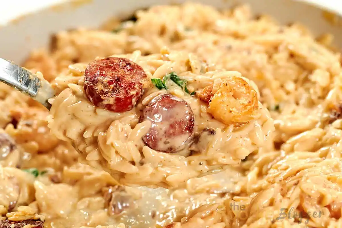 Creamy Cajun Shrimp Orzo 16 Close-up of creamy Cajun shrimp orzo in a skillet with shrimp, sausage, and creamy Cajun sauce.