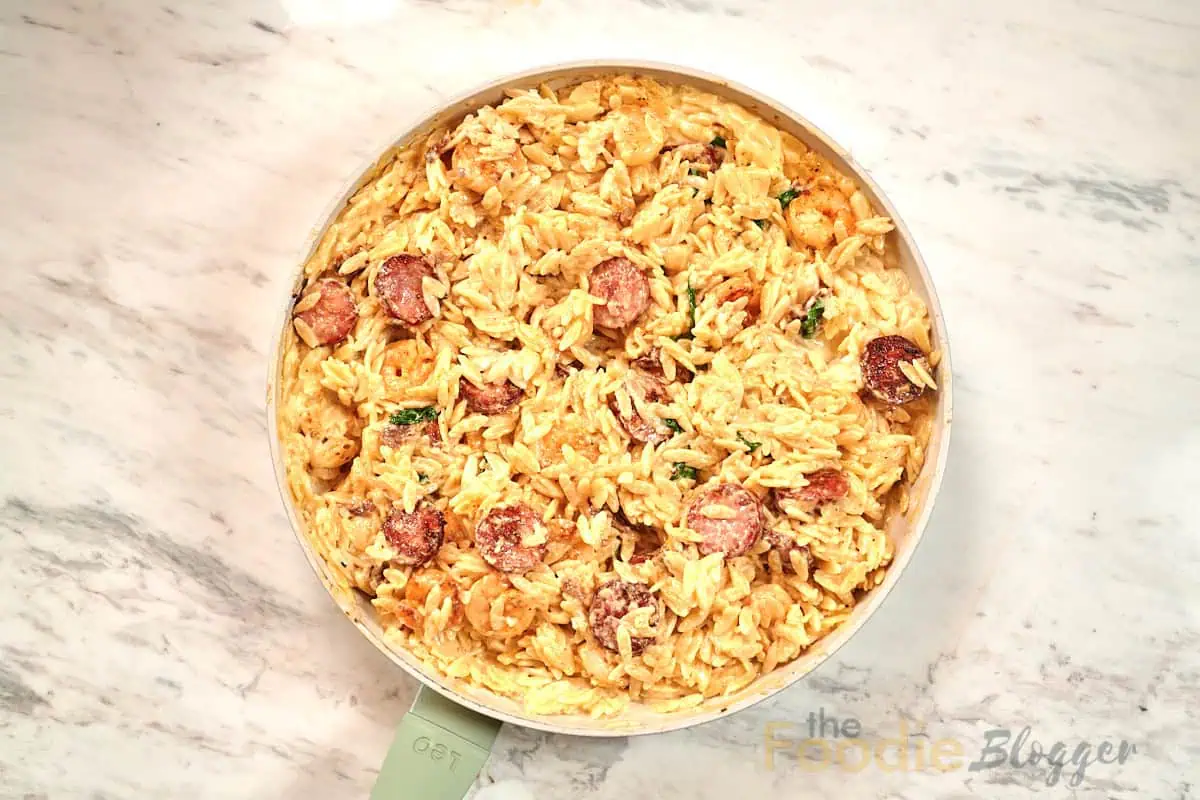 Creamy Cajun Shrimp Orzo 2 Overhead view of creamy Cajun shrimp orzo skillet with shrimp, sausage, and spinach.