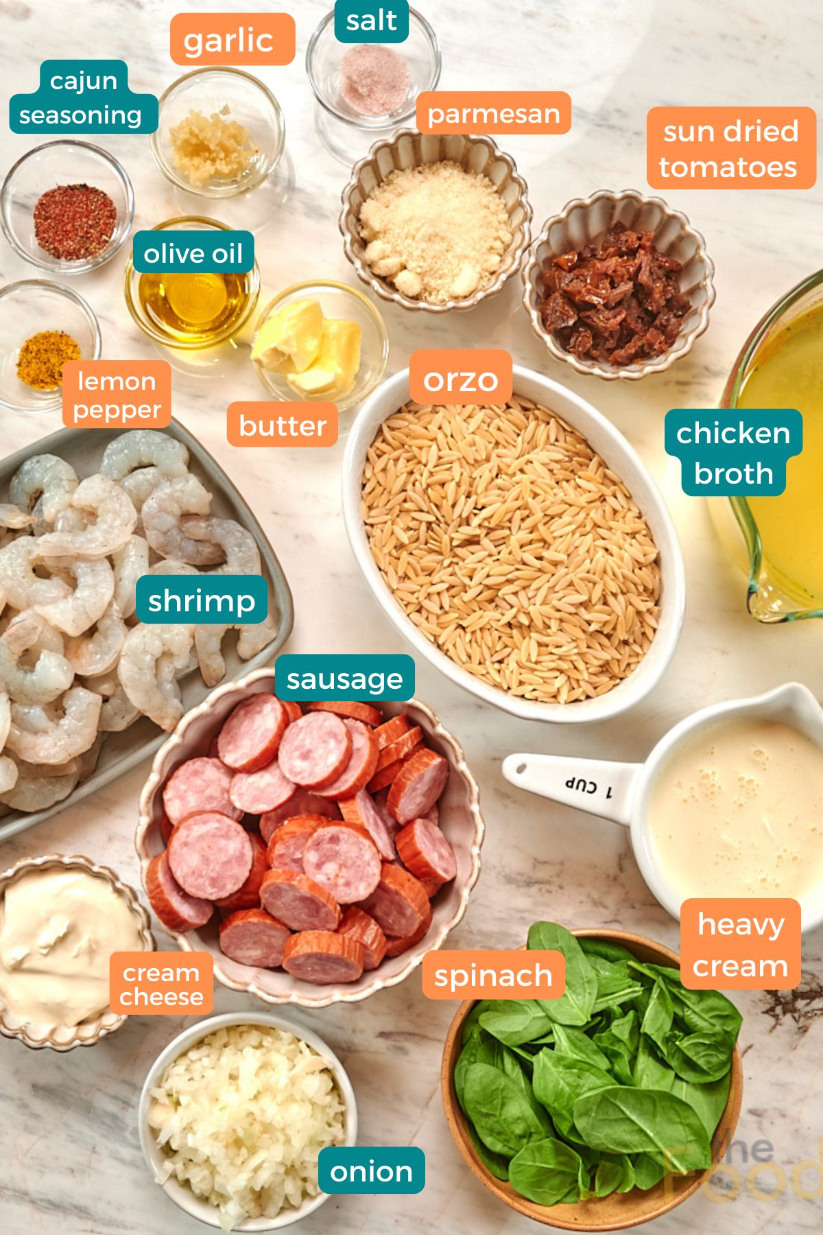 Creamy Cajun Shrimp Orzo 4 Ingredients for creamy Cajun shrimp orzo including shrimp, smoked sausage, orzo pasta, spinach, broth, cream, parmesan, Cajun seasoning, garlic, and onion.