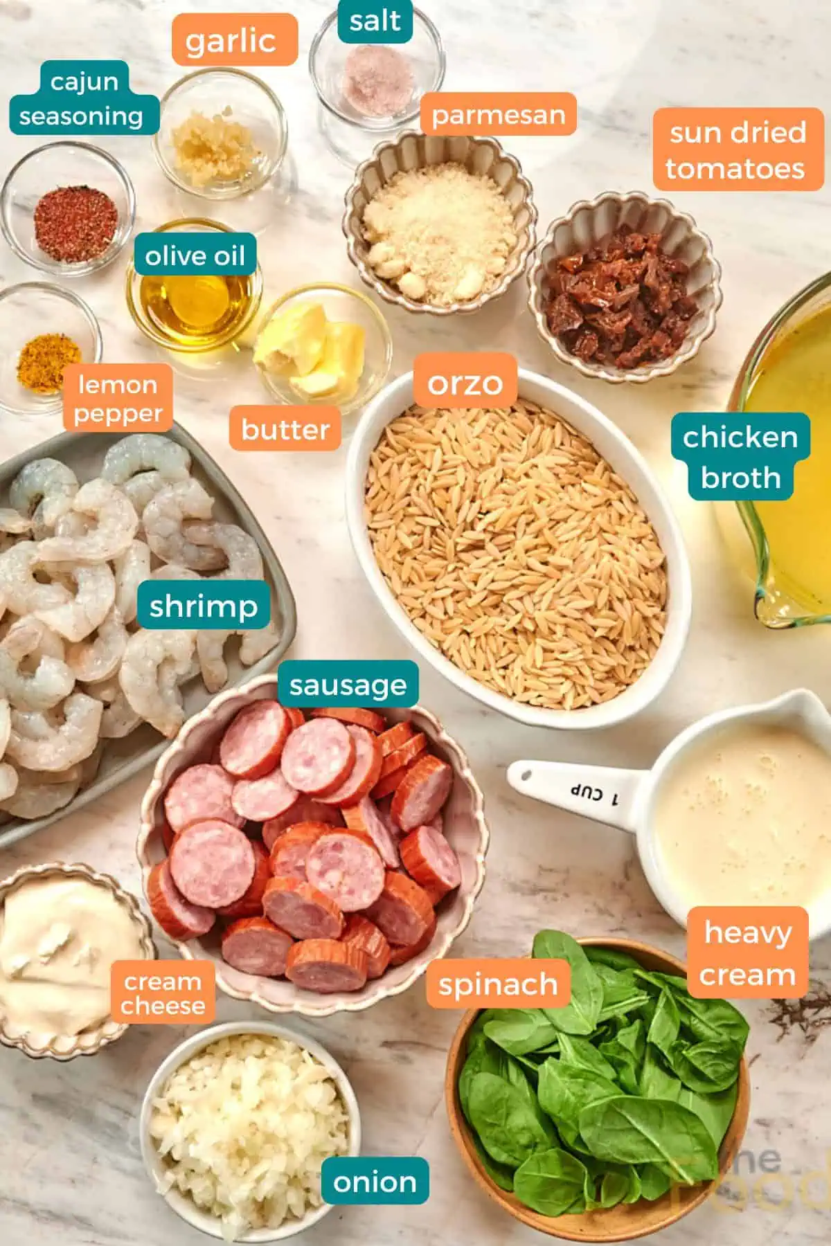 Creamy Cajun Shrimp Orzo 4 Ingredients for creamy Cajun shrimp orzo including shrimp, smoked sausage, orzo pasta, spinach, broth, cream, parmesan, Cajun seasoning, garlic, and onion.