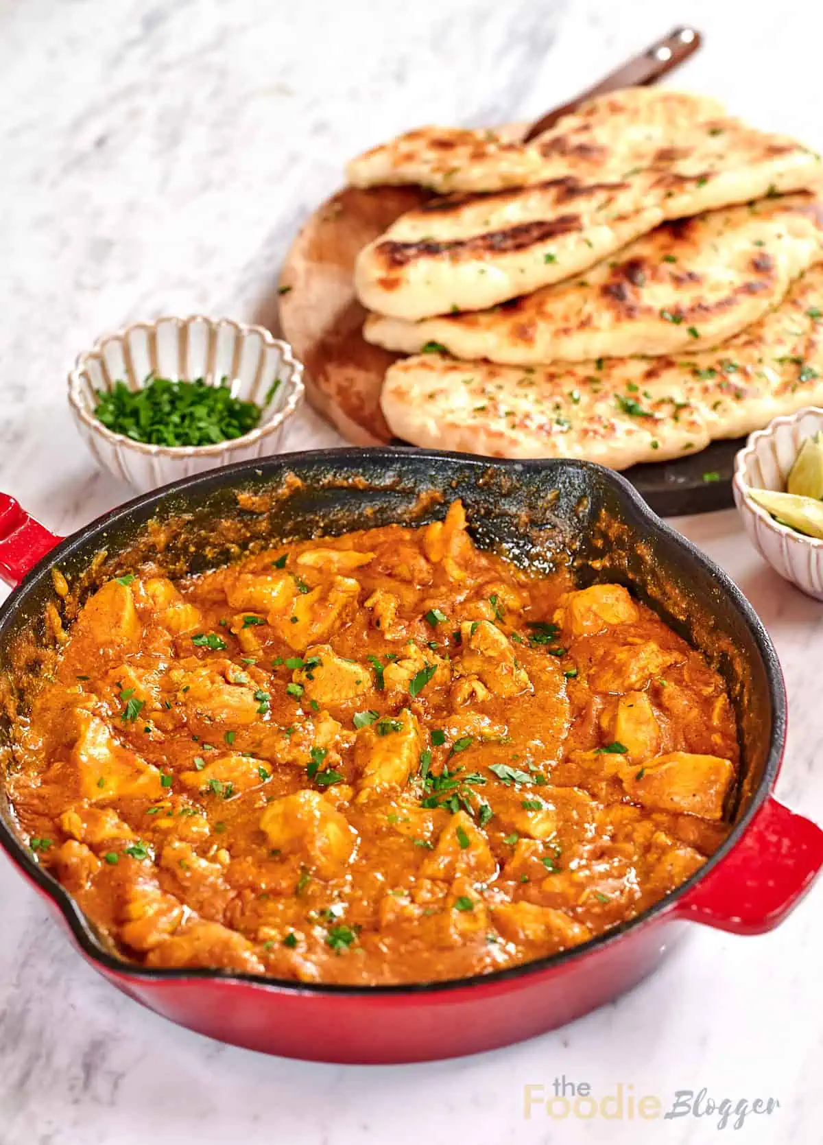 Creamy Chicken Coconut Curry 2 Skillet filled with creamy coconut chicken curry garnished with fresh parsley and served with naan bread.