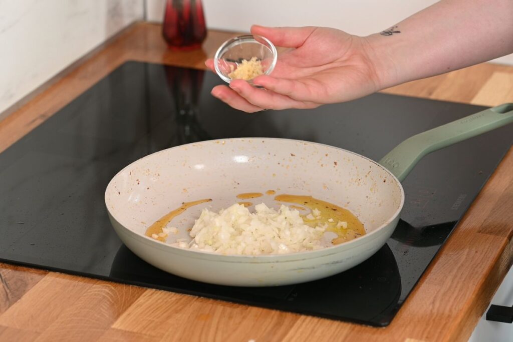 Creamy Cajun Shrimp Orzo 8 Cooking diced onion and garlic in the skillet for creamy Cajun shrimp orzo.