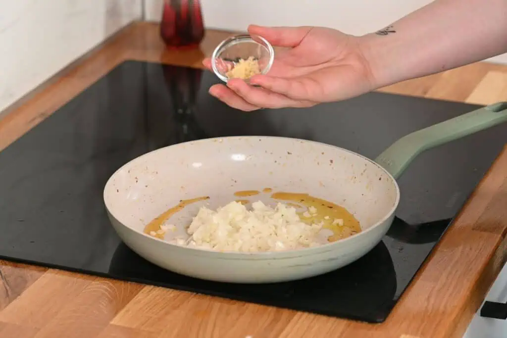 Creamy Cajun Shrimp Orzo 8 Cooking diced onion and garlic in the skillet for creamy Cajun shrimp orzo.